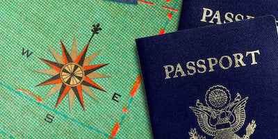 Two Passports Laying Next to the Compass on a Map