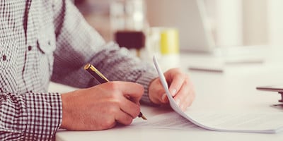 Man Signing Stack of Papers