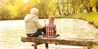 Grandfather and Grandson Fishing in Small Pond